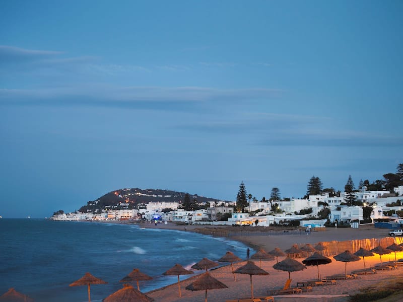 La Marsa beach at dusk with straw parasols